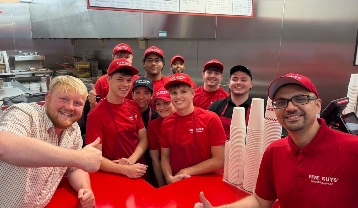 Five Guys employees smiling for a photo with Kaleb Cooper to launch collab with Hawkstone Cider